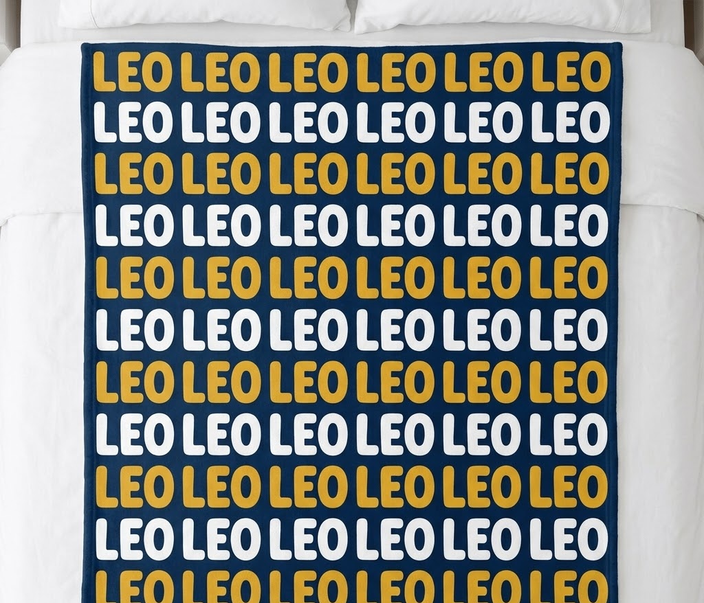 Kids name repeat blanket with Leo in mustard and white rows on a bed