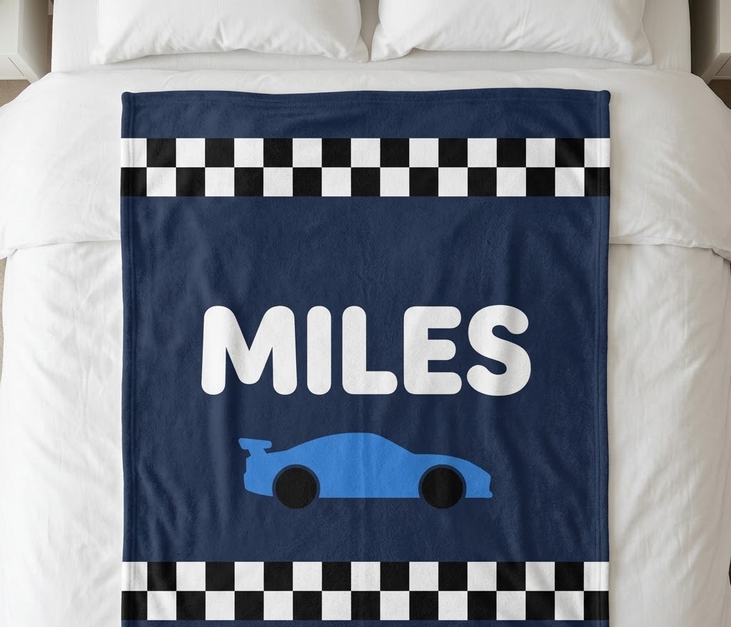 Race car name blanket with MILES and a blue car, flat on a bed