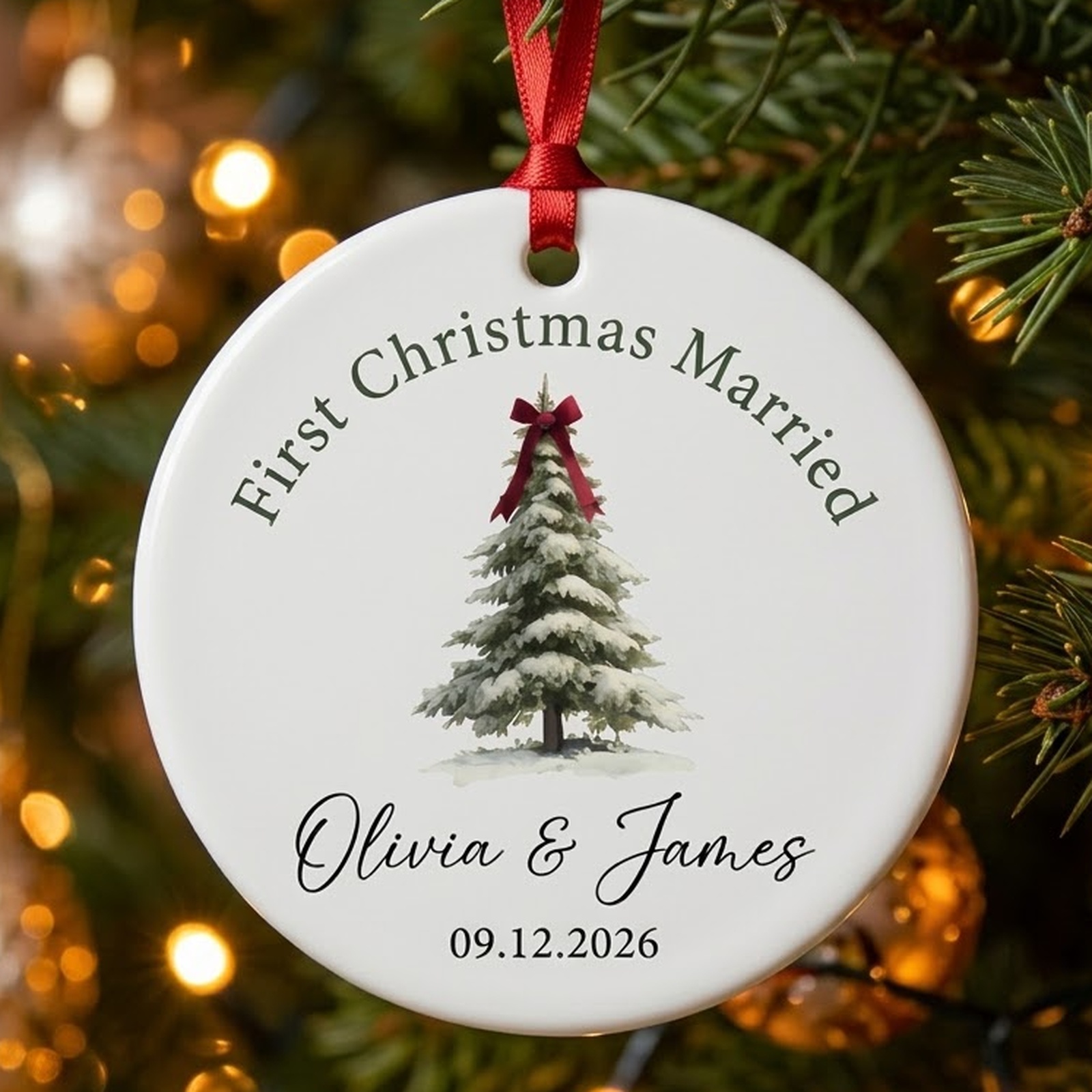 First Christmas Married ceramic ornament with a snowy pine tree tied with a red bow and the names Olivia and James with a wedding date